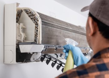The man cleaning air conditioner indoor unit. Maintaining the air conditioner concept.